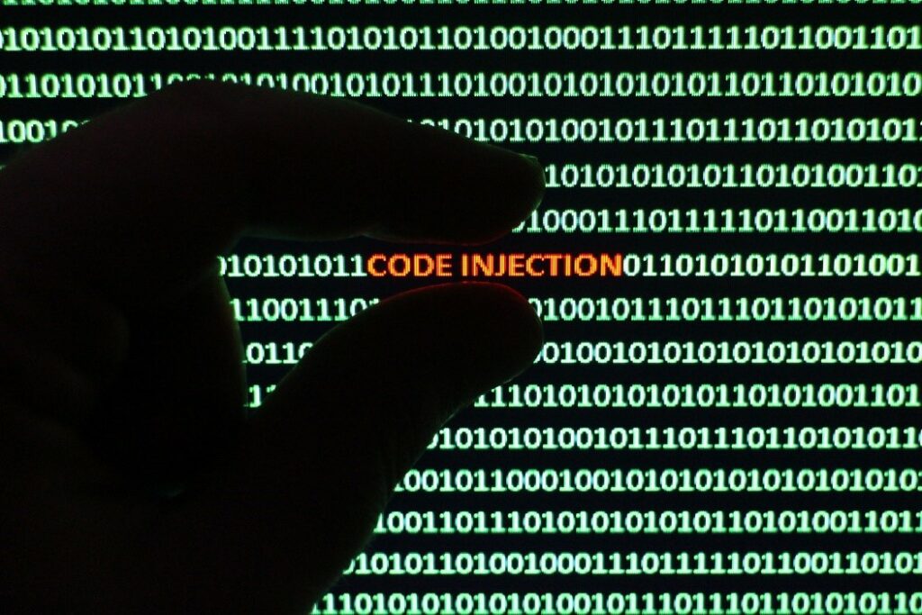 A screen with code written in green and "code injection" in orange as an encryption threat. 